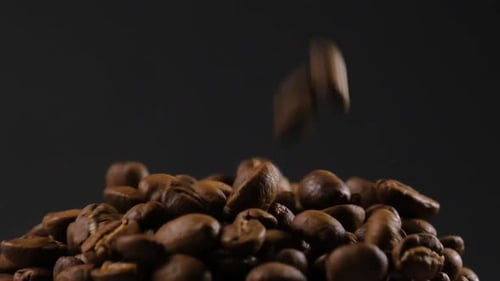 Movimiento lento de los granos de café tostados que caen.