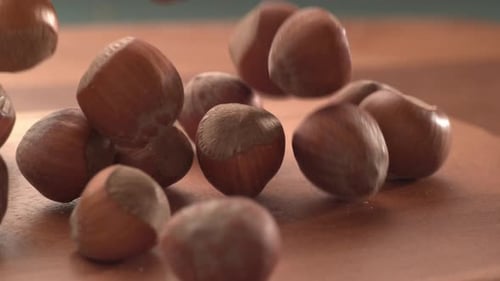 Hazelnuts Falling onto a Wooden Surface