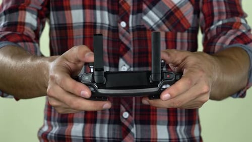 Man in a Controls the Remote Control From the Computer. Close Up