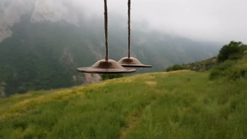 Campana tradicional indígena nómada dorada colgada en una terraza de madera con un hermoso paisaje
