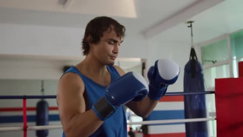 Caucasian man boxing in boxing gym