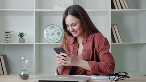 Happy Woman Using Phone in Modern Office