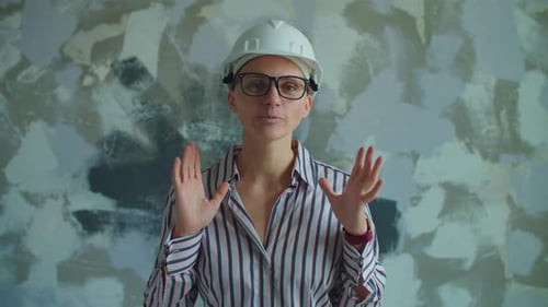 Woman in Hard Hat Speaking to Camera