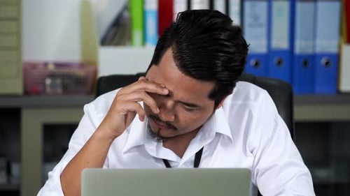 Man Frowning and Stressed at Work in Office