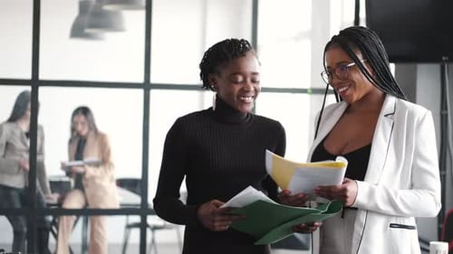 Two Young Women Working Together in an Office