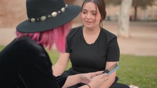 Young Women Using Phone in a Park