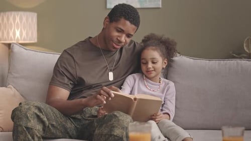 Man and Child Reading a Book Indoors