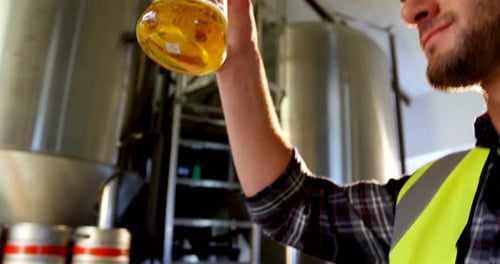 Close-up of brewer testing beer