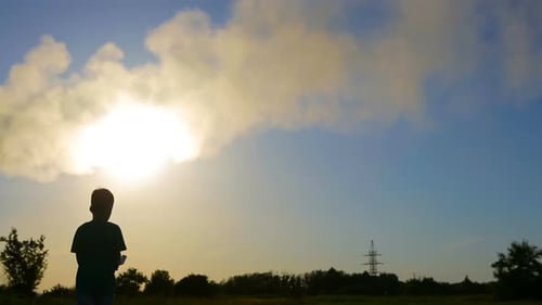 Child Launches Paper Airplane at Sunset