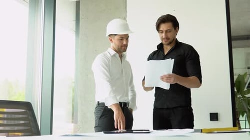 Engineers Discuss Building Plans and Shake Hands