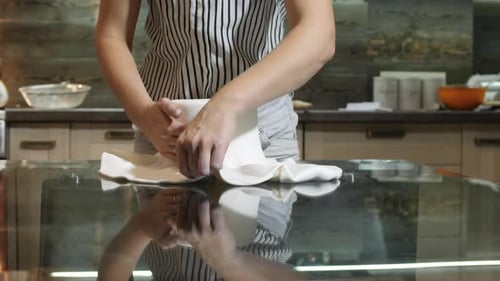 Young Adult Decorating White Fondant Cake in Kitchen