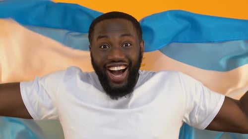 Man Cheering and Raising Arms with Flag