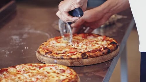 Chef cutting pizza. Chef cutting freshly prepared pizza