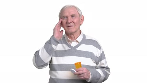 Senior Man with Headache and Medicine Bottle