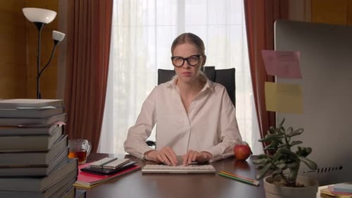 Beautiful Young Woman at Table, Searching Internet, Sees Something Unpleasant