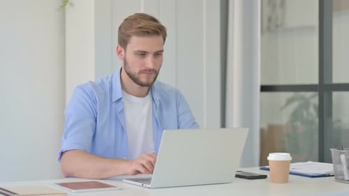Man Working on Laptop Gives Thumbs Up
