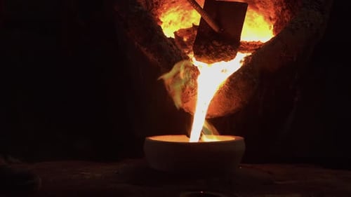 Molten Metal Pours Into Bowl in Dark Factory
