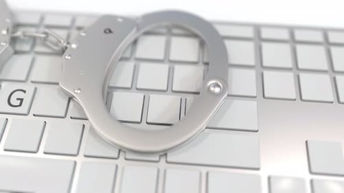 Cybercrime Concept: Handcuffs Spell SPYING on Keyboard
