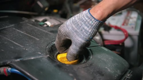 Autowerkstatt - Arbeiter prüft den Zustand des Motoröls