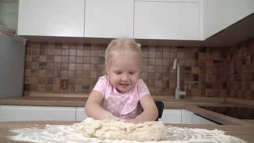 Cute Girl Kneading Dough in Kitchen