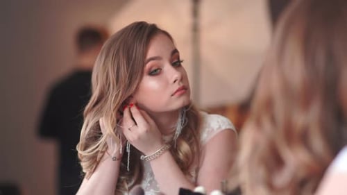 Woman Putting on Earring for an Elegant Event