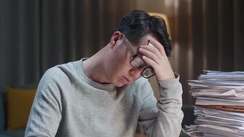Close Up Of Sick Asian Man Tried While Working Hard With Documents At The Home
