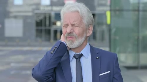 Man in Suit Experiencing Neck Pain Outdoors