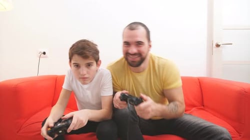 Father and Son Playing Video Games Together at Home