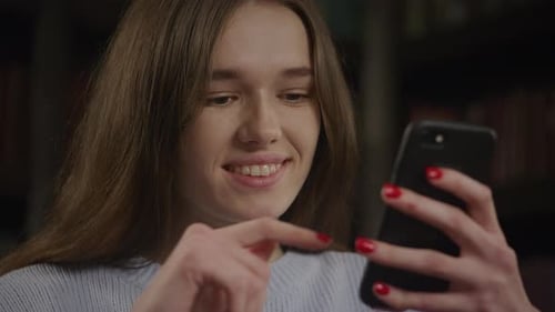 Close Up of a Young Adult Caucasian Woman Browsing Online on Her Smart Phone