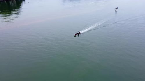 Aerial view from a drone of Thai traditional longtail fishing boats sailing in the sea.