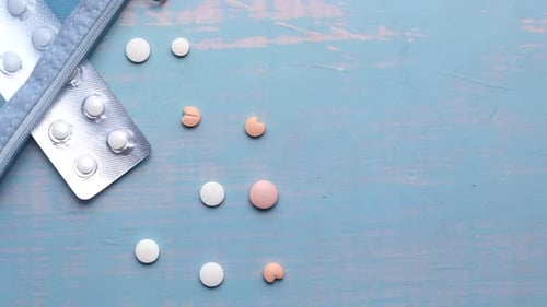Weiße Pillen und Blisterpackung auf blauem Hintergrund