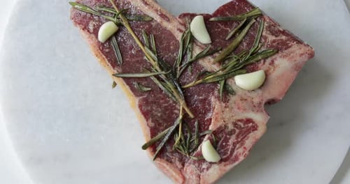 Steak frais T-Bone ou Porterhouse vieilli à sec sur planche à découper en marbre. Faire mariner dans de l'huile d'olive et de