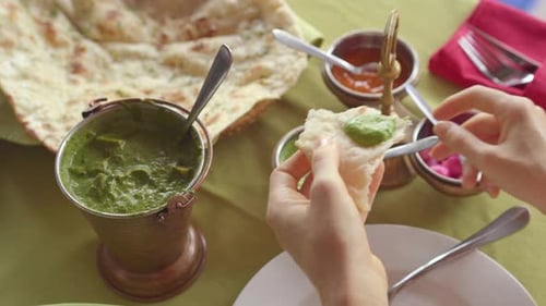 A Young Caucasian Woman Enjoing Indian Food in a Restaurant. Indian Food Concept