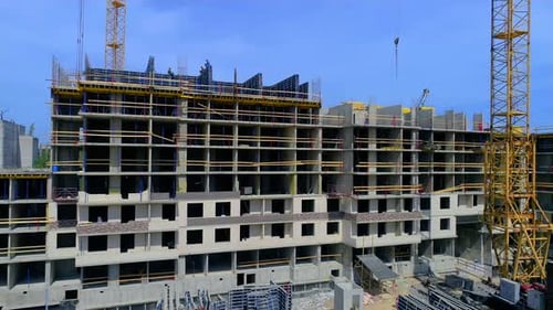 Construction of a new gray multi-storey building from panels. Drone footage