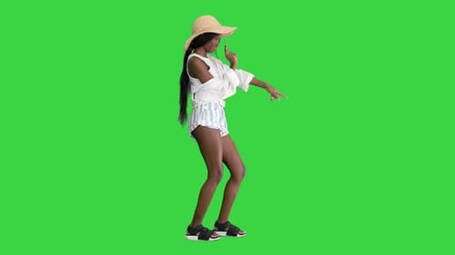 Cheerful African American Girl in a Straw Hat Dancing on a Green Screen, Chroma Key.