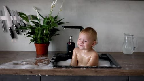 Laughing Baby Splashing in Kitchen Sink Bath