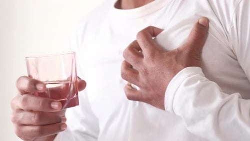 Adult with Chest Pain Holding Glass of Water