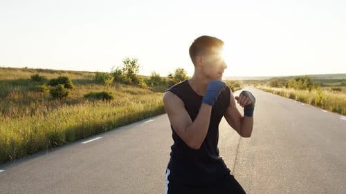 Male Boxer Training on Country Road at Sunrise