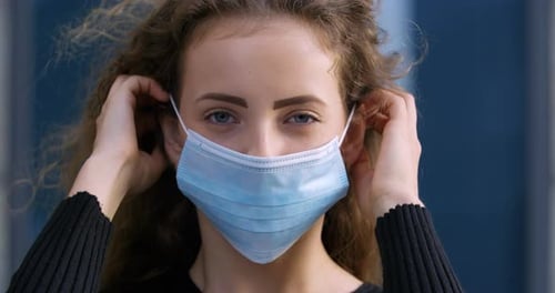 Young Woman Putting on a Surgical Mask