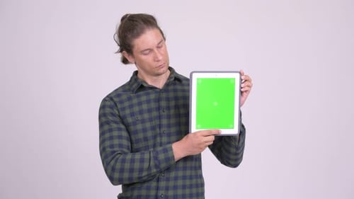 Young Adult Holding a Tablet with a Green Screen