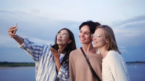 Three Smiling Young Women Take a Selfie Outdoors