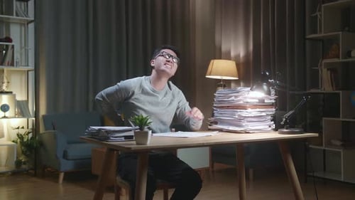 Overworked Adult Experiencing Back and Neck Pain at Desk