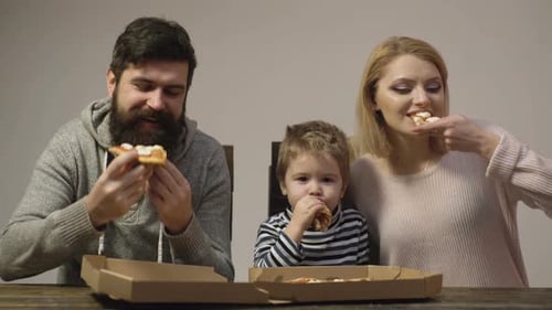 Happy Family Eating Pizza Together at Home
