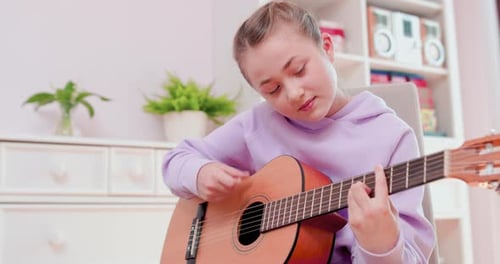 Girl Playing Acoustic Guitar in Her Room
