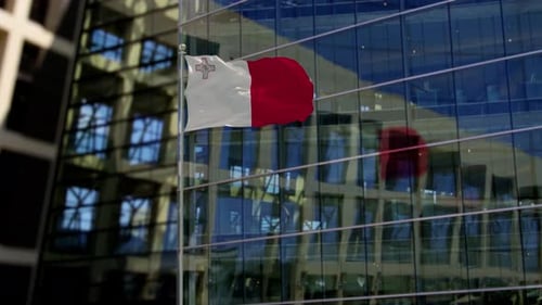 Maltese Flag Waving on Modern Corporate Building