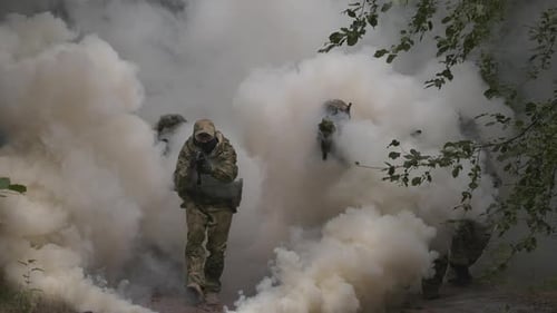 Figures in Camouflage Emerge From Smoke in Forest