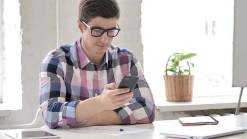 Man Using Mobile Phone at Bright Desk