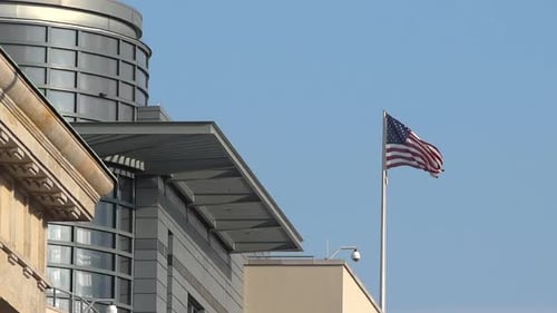 American Flag Waving by Modern Building