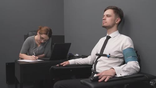 Man Undergoing Polygraph Lie Detector Test in Office