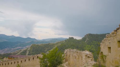 Tourists in abandoned stone city in mountains